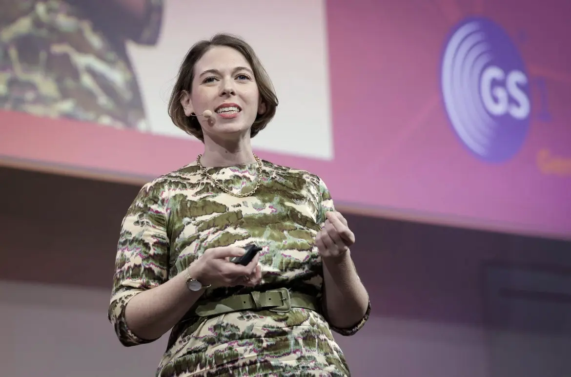 Dorothee Ebert spricht energiegeladen auf einer großen Bühne vor Publikum